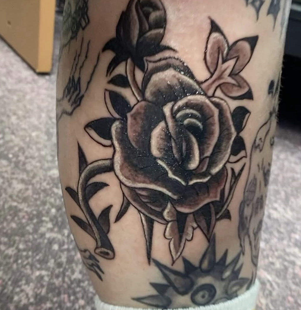 Black-and-grey traditional rose tattoo by Sam Strasshofer