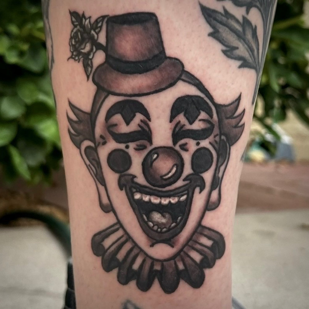 Black-and-grey traditional clown tattoo